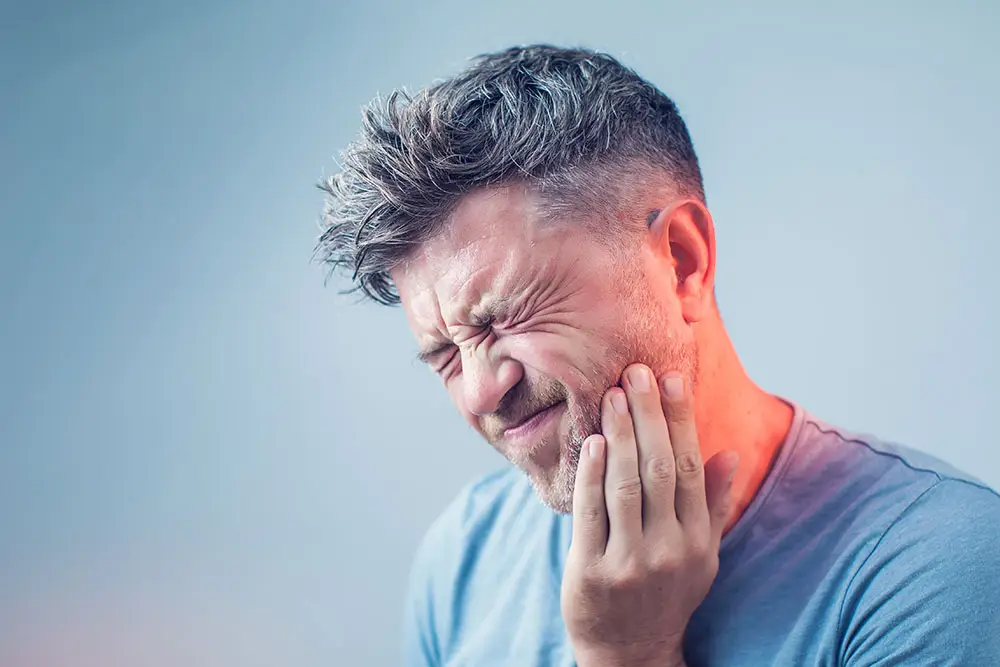 Man holding mouth in pain