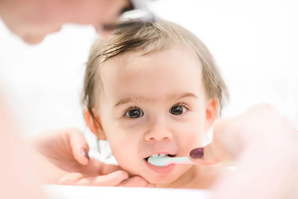 Baby getting her teeth brushed